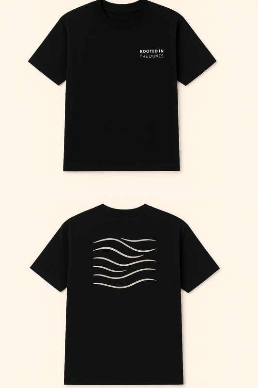 Black t-shirt with text on the front and wave design on the back against a beige background